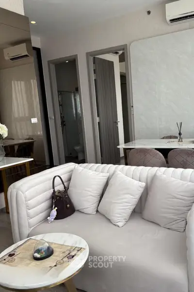 Modern living room with elegant sofa and dining area in a stylish apartment.
