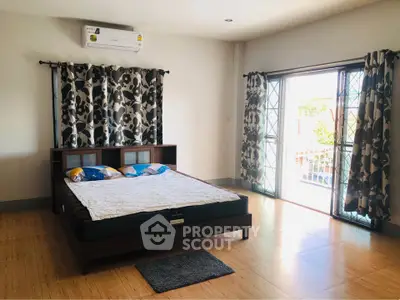 Spacious bedroom with natural light and balcony access