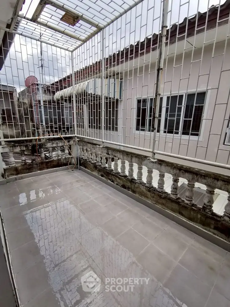 Spacious balcony with tiled flooring and secure railing, perfect for outdoor relaxation.