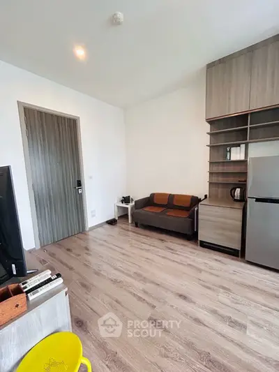 Modern living room with sleek wooden flooring and compact furniture