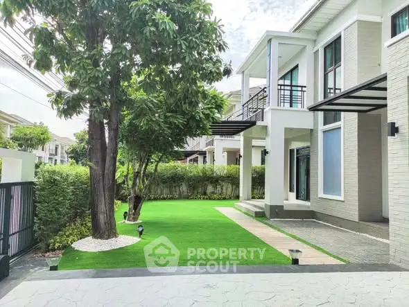 Stunning modern home exterior with lush green lawn and elegant architecture, perfect for family living.