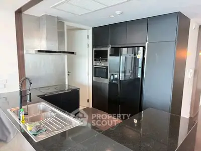 Modern kitchen with sleek black cabinetry and stainless steel appliances