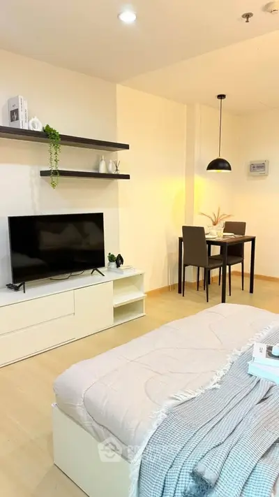 Modern living room with sleek TV setup and cozy dining area, perfect for urban living.