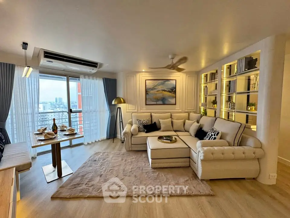 Luxurious living room with elegant decor and city view, featuring a spacious sectional sofa and stylish shelving.