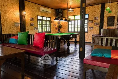 Charming rustic interior with pool table and cozy seating, perfect for entertainment and relaxation.