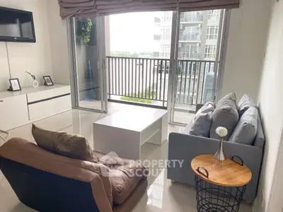 Modern living room with balcony view, stylish furniture, and natural light.