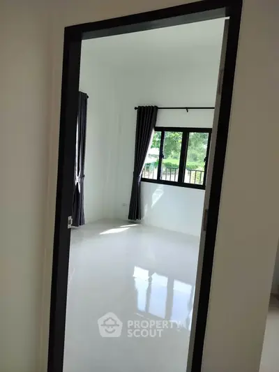 Bright and airy room with large window and modern curtains, perfect for natural light lovers.