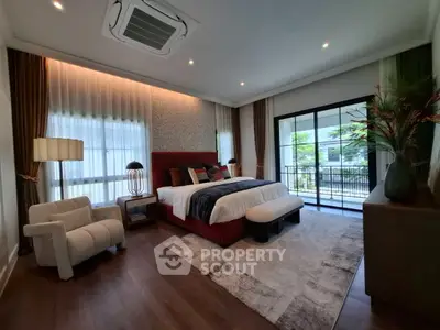 Luxurious bedroom with modern decor and large windows opening to a balcony view.