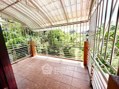 Spacious balcony with metal railings and lush green view