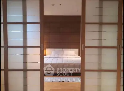 Elegant bedroom with sliding doors and cozy lighting, perfect for relaxation.