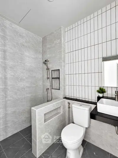 Modern bathroom with sleek design, featuring a shower and stylish fixtures.