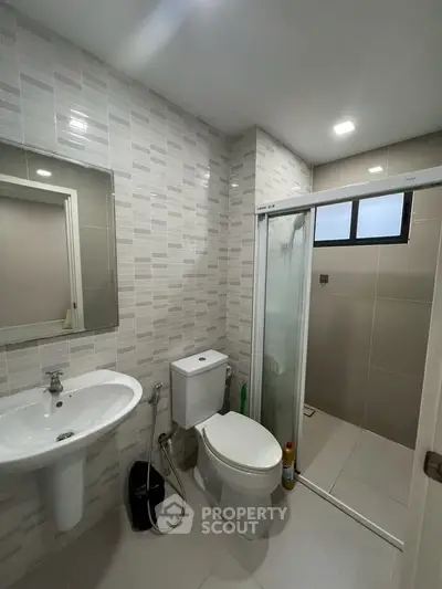Modern bathroom with sleek design featuring shower and toilet