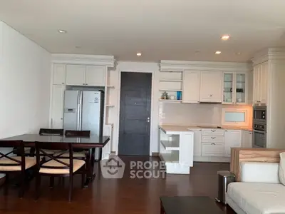 Spacious open-layout kitchen with dining area and modern appliances in elegant apartment.