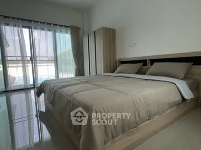 Spacious bedroom with pool view and modern furnishings