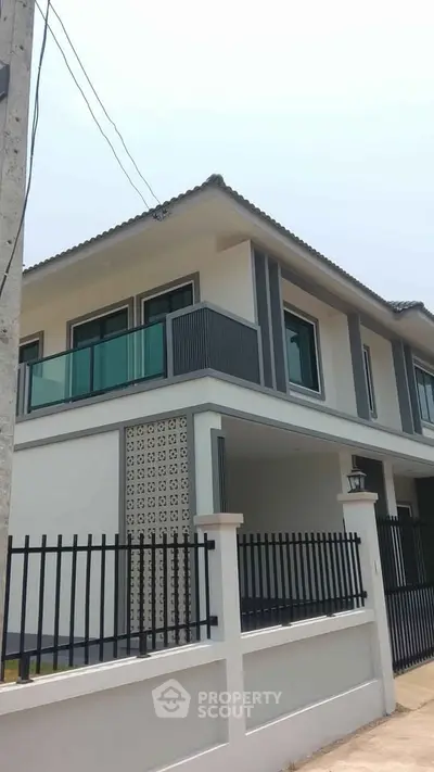 Modern two-story house with sleek balcony and stylish facade in a desirable neighborhood.