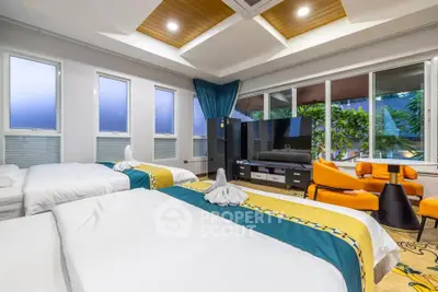 Luxurious bedroom with modern decor and large windows offering garden views.