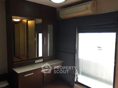 Modern bedroom with built-in wardrobe and balcony access, featuring sleek design and natural light.