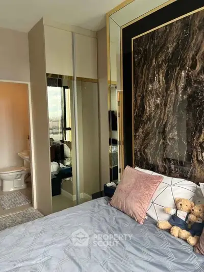 Luxurious bedroom with elegant decor and plush bedding, featuring a stylish mirrored wardrobe and marble accent wall.