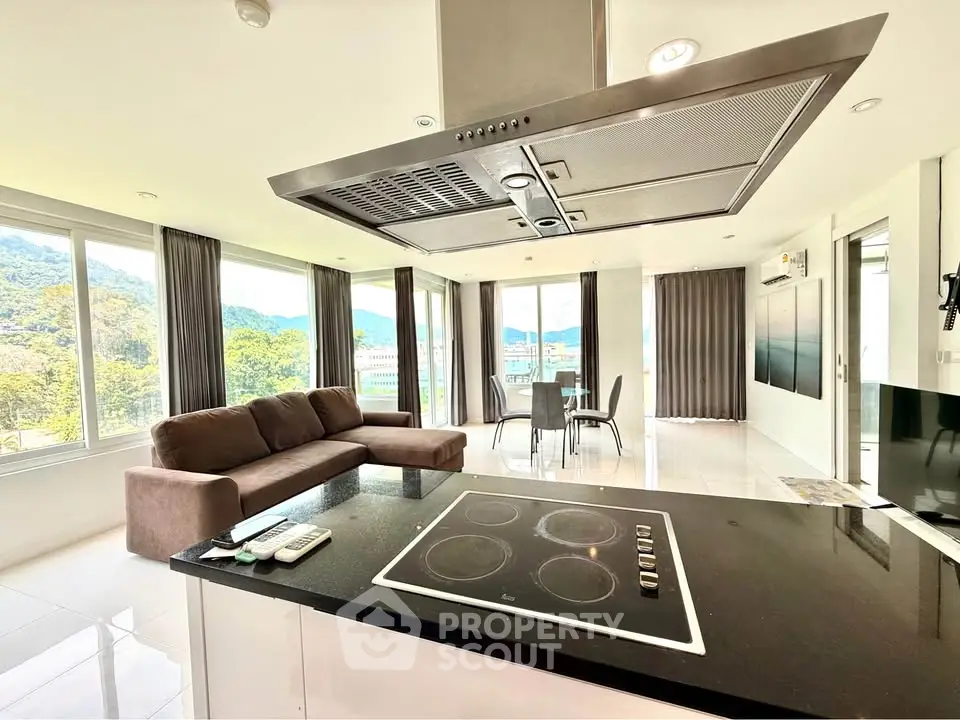 Spacious open-plan living room with modern kitchen and stunning mountain views.