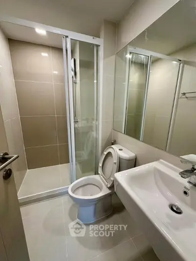 Modern bathroom with sleek shower and elegant fixtures in a contemporary apartment.