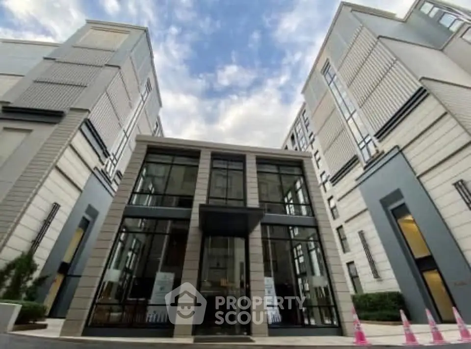 Modern building entrance with sleek glass facade and contemporary design.