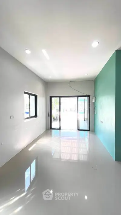 Spacious modern living room with large windows and glossy floor tiles.