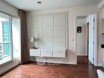 Spacious room with elegant wooden flooring and large window, perfect for modern living.