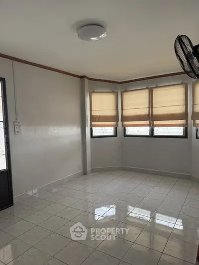 Spacious unfurnished room with tiled flooring and large windows for natural light