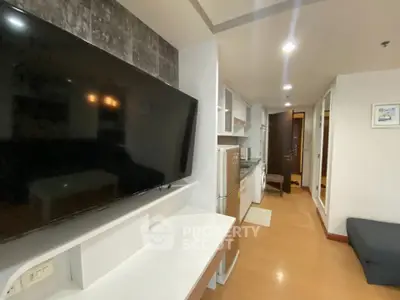 Modern apartment interior with TV, kitchen appliances, and stylish decor