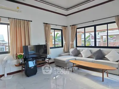 Spacious living room with modern decor and large windows offering natural light.