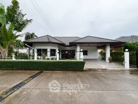 Charming single-story house with modern design and lush greenery in a serene neighborhood.