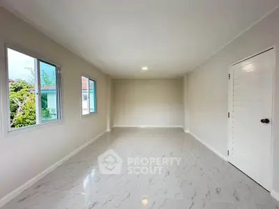Spacious empty room with tiled flooring and large windows in modern home