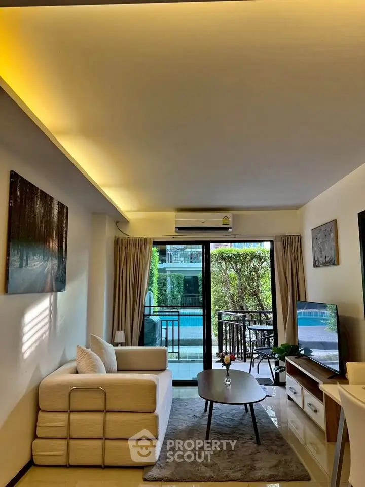 Modern living room with pool view, featuring cozy white sofa and stylish decor.