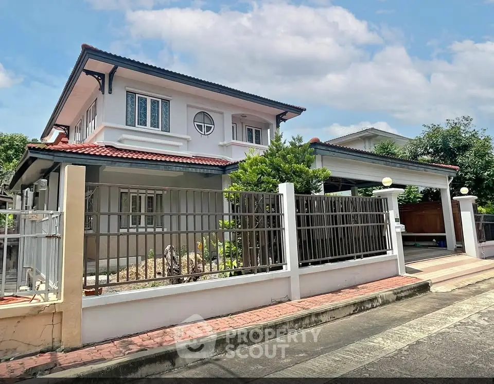 Charming two-story house with red-tiled roof and spacious driveway in a serene neighborhood.