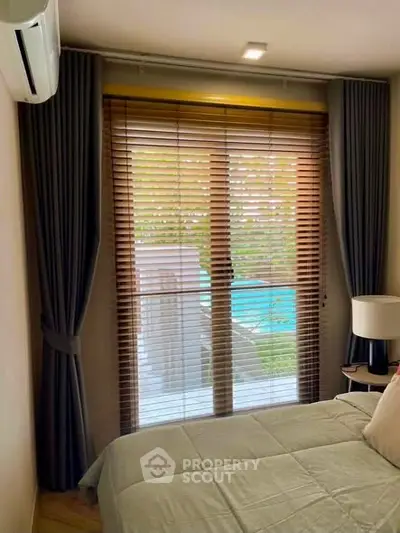 Cozy bedroom with pool view, featuring elegant blinds and modern decor for a serene living experience.