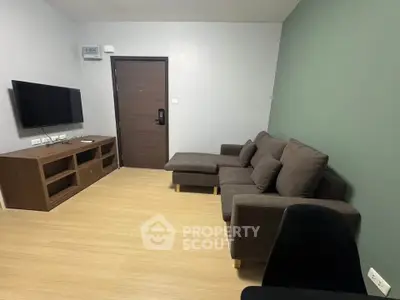 Modern living room with sleek furniture and wall-mounted TV in a cozy apartment.