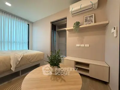 Modern bedroom with air conditioning and stylish decor, featuring a cozy bed and elegant wooden furniture.