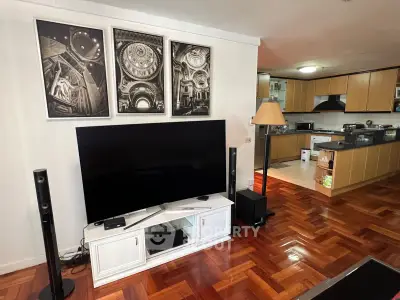 Spacious living room with modern kitchen, hardwood floors, and stylish decor in a contemporary apartment.