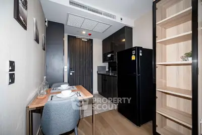 Modern compact kitchen with dining area and sleek black appliances
