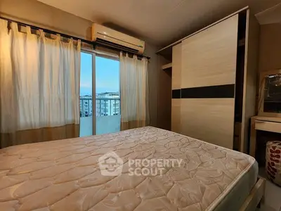 Cozy bedroom with large window and city view, featuring modern wardrobe and air conditioning.