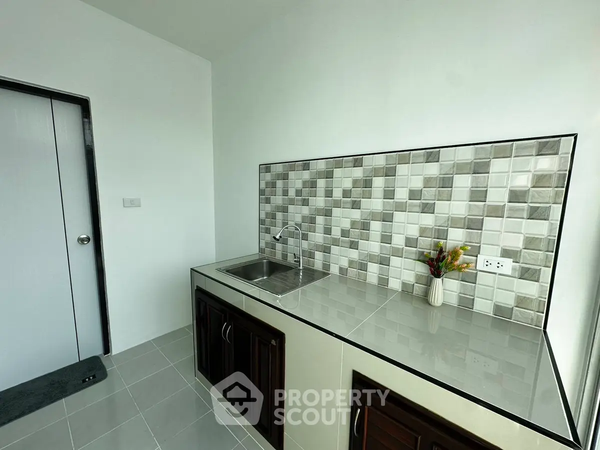 Modern kitchen with sleek tile backsplash and stainless steel sink