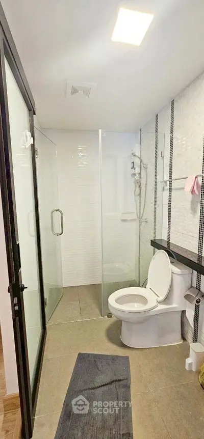 Modern bathroom with glass shower and sleek fixtures in a contemporary home.