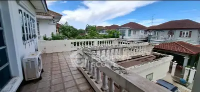 Spacious balcony with scenic neighborhood view and classic railing design.