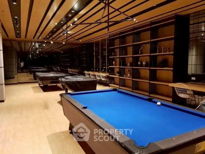 Luxurious billiards room with modern design and ample seating in upscale residential building.