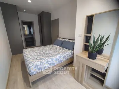Modern bedroom with stylish decor and wooden furniture, featuring a cozy bed and a sleek vanity with a mirror.