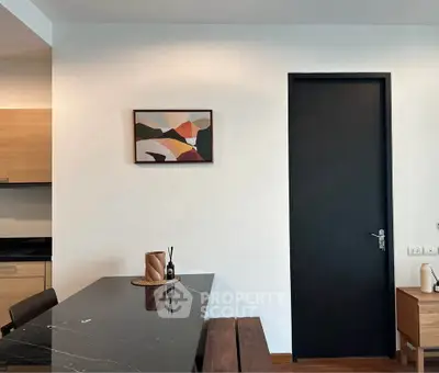 Modern dining area with sleek black table and abstract art on wall
