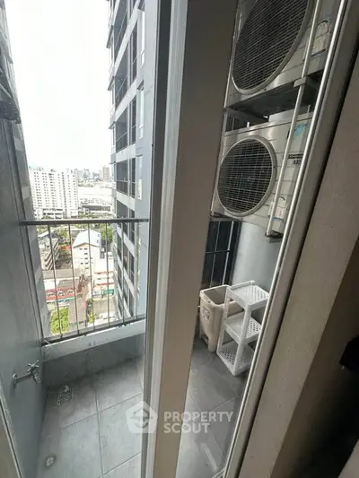 Modern high-rise balcony with city view and air conditioning units, perfect for urban living.