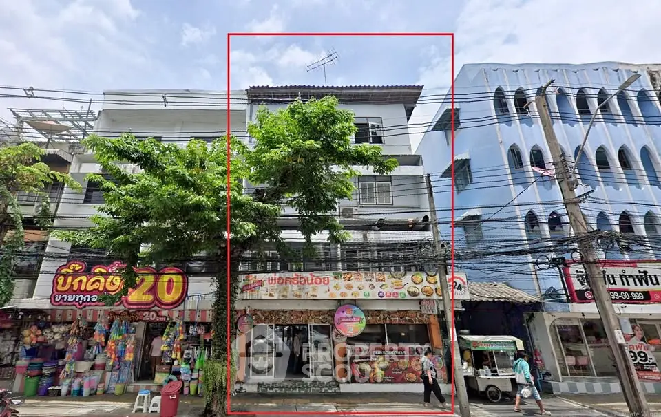 Commercial building with retail shops on a busy street, ideal for business opportunities.