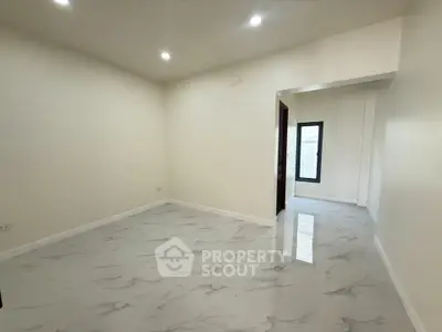 Spacious empty room with marble flooring and recessed lighting, ideal for customization.