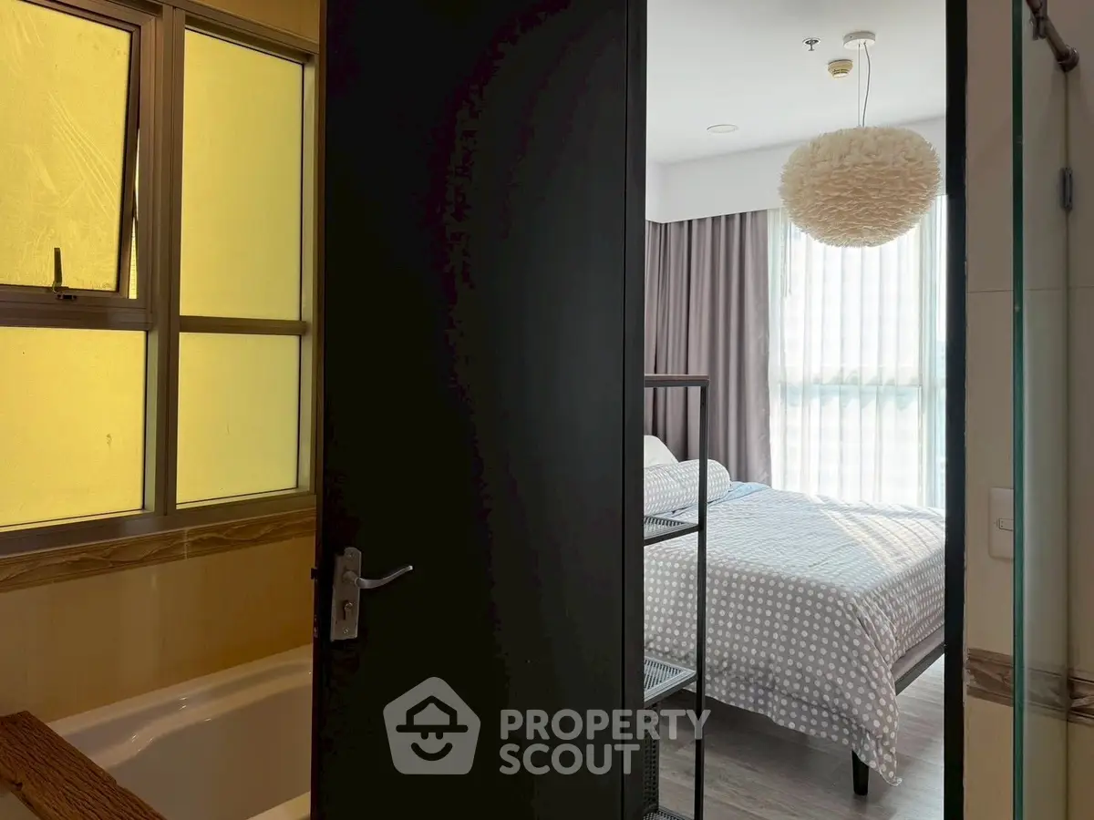 Cozy bedroom with ensuite bathroom featuring modern design and natural light.